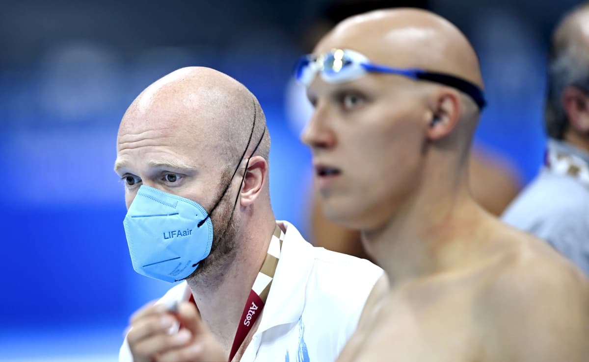 Kuvassa etualalla uimari Matti Mattsson uimalasit päässä, takana Mattssonin valmentaja Eetu Karvonen hengityssuoja kasvoilla.