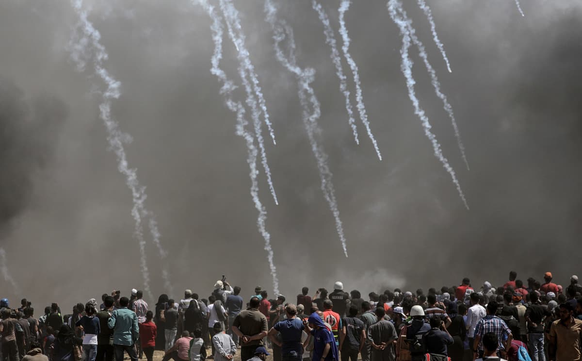 Palestiinalaismielenosoittajat juoksevat karkuun Israelin ampuessa kyynelkaasua Gazan ja Israelin rajalla.