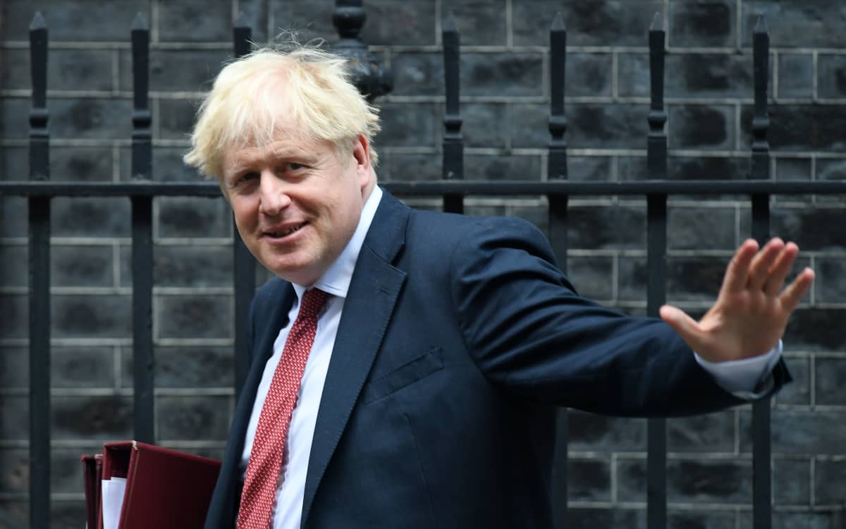 Boris Johnson heilauttaa kättään.
