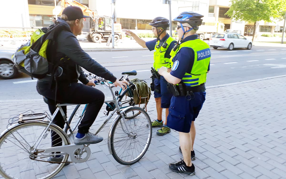 poliisit neuvomassa pyöräilijää