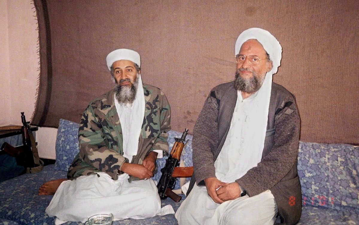 Osama bin Laden ja Ayman al-Zawahiri istuvat jossakin Afganistanissa marraskuussa 2001. Miesten välissä on rynnäkkökivääri. 