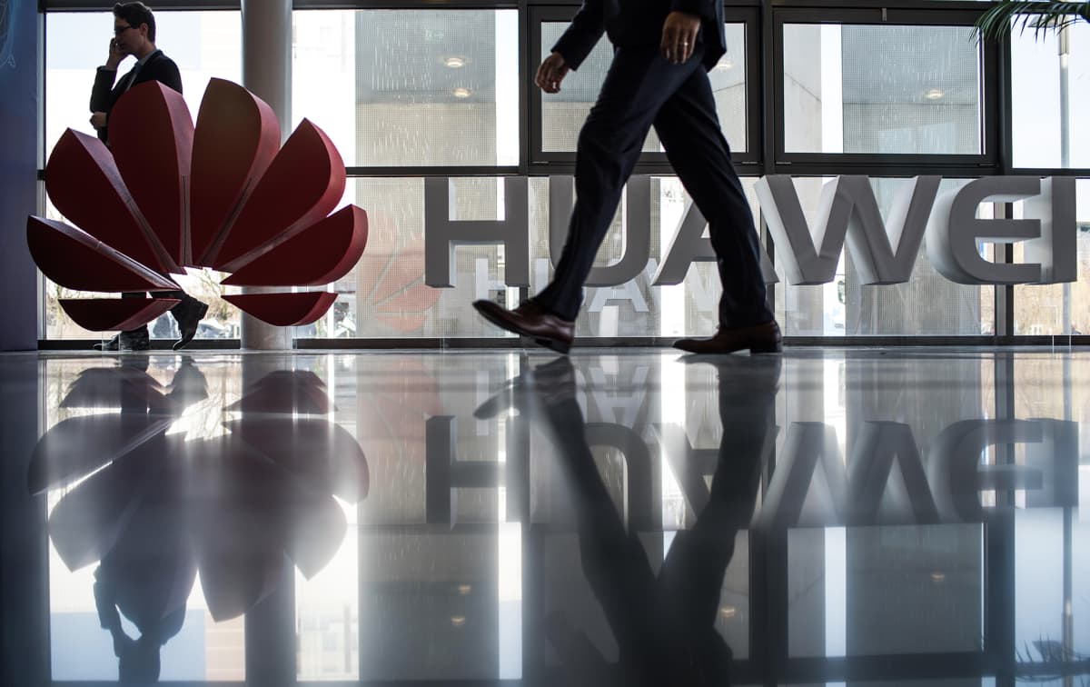 Mies kävelee Huawei logon ohi