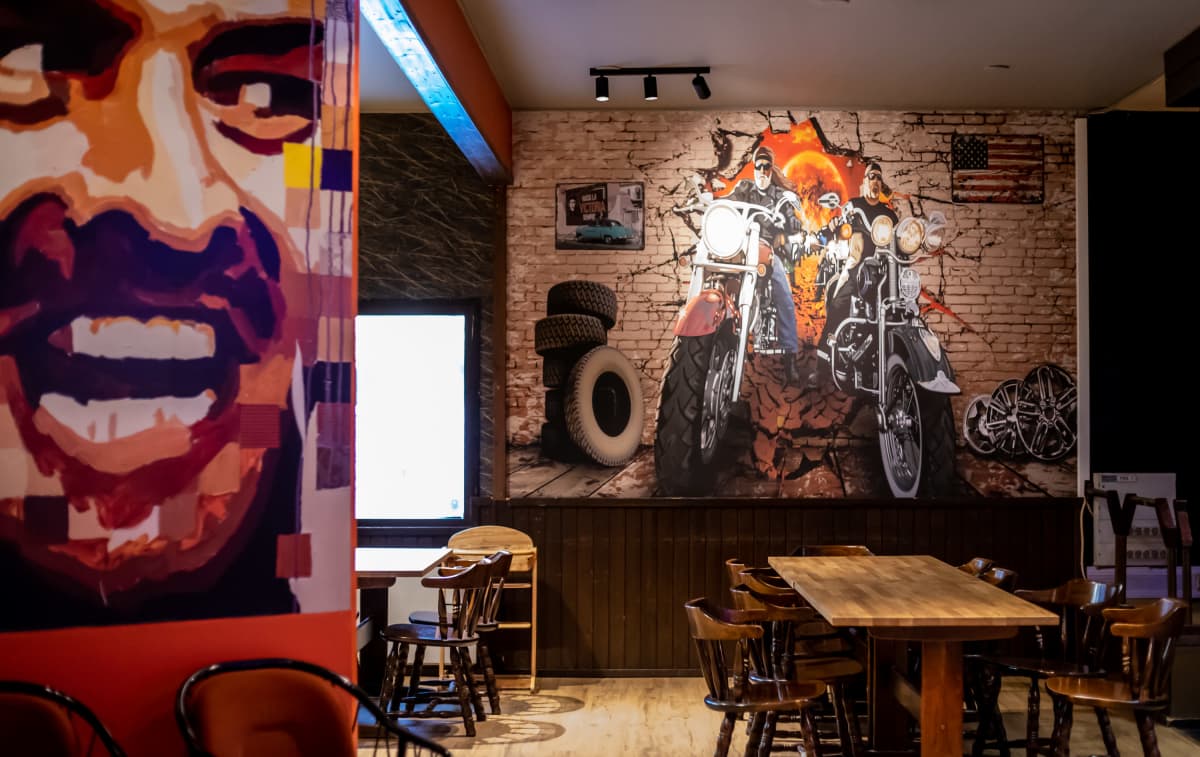 Ravintolan seinällä on iso seinämaalaus moottoripyöristä.