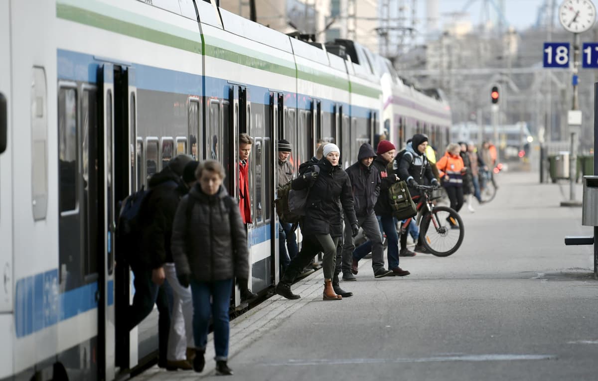 Junamatkustajia nousee lähijunasta Helsingin Päärautatieasemalle torstaiaamuna 26. maaliskuuta