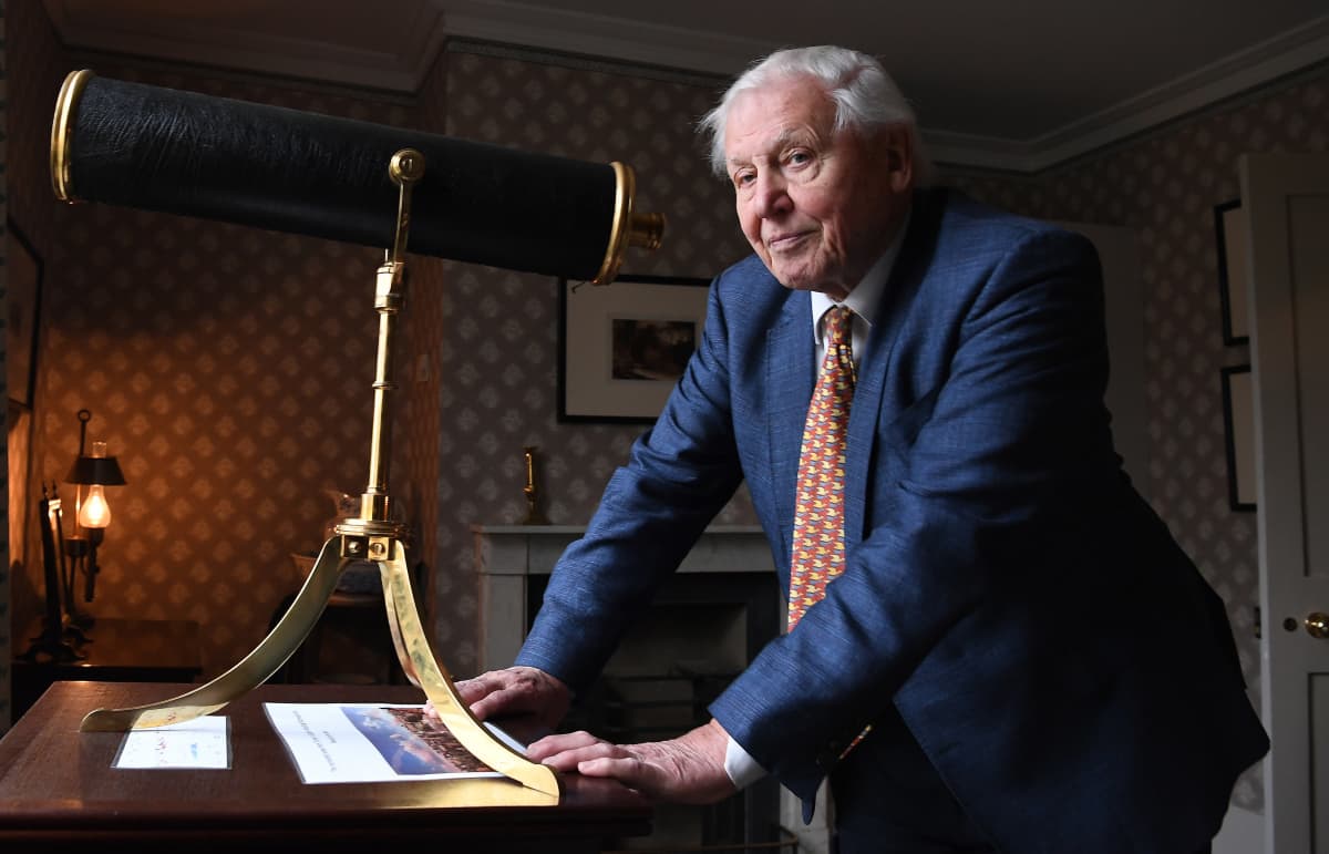 Sir David Attenborough poseeraa kaukoputken kanssa.