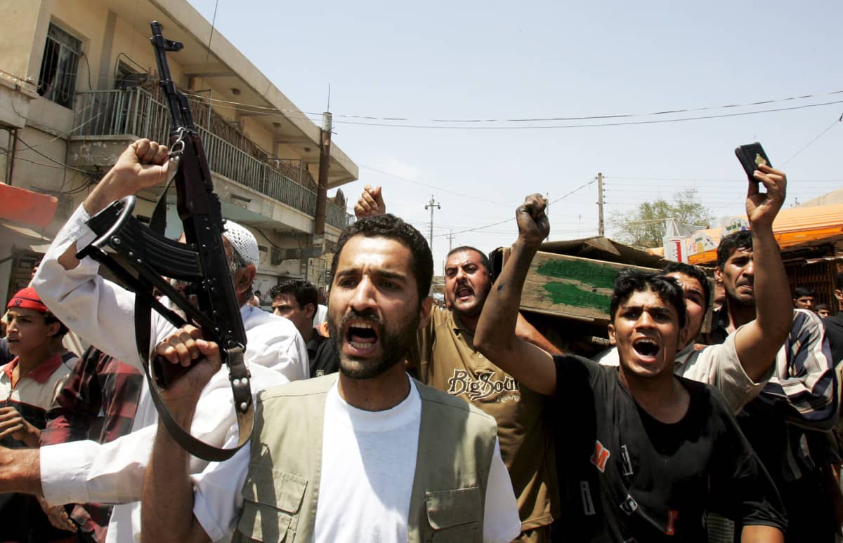Sunnimiehet kantavat shiiojen ja sunnien välisissä väkivaltaisuuksissa kuolleen miehen arkkua hautajaisissa toukokuussa 2005 Bagdadissa.