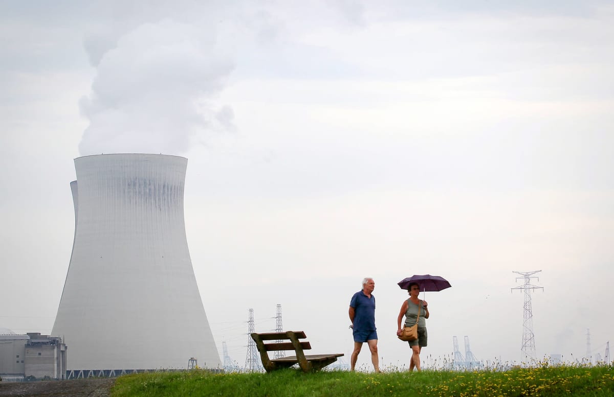 Ett par går vid ett kärnkraftsverk i Belgien.