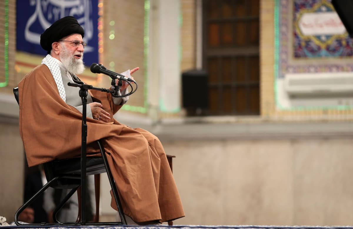 Ali Khamenei istuu tuolilla ja pitää puhetta.