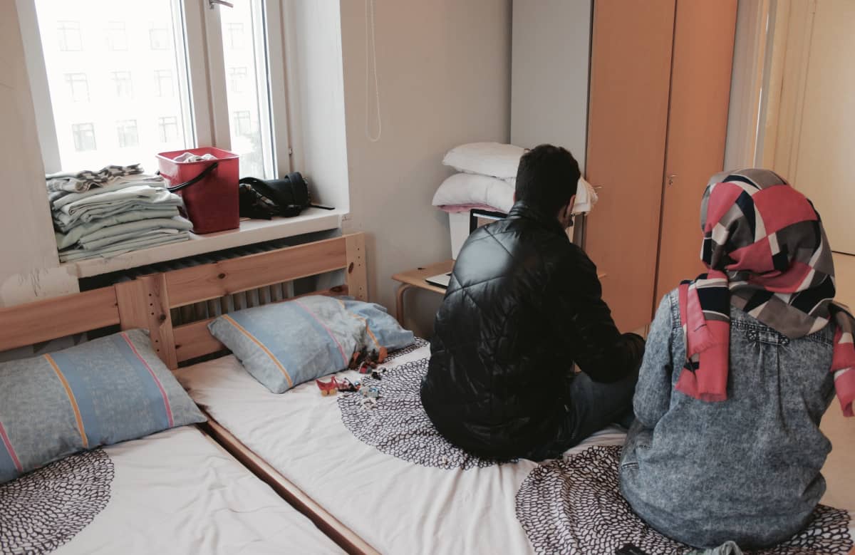 En man och en kvinna sitter på en säng.