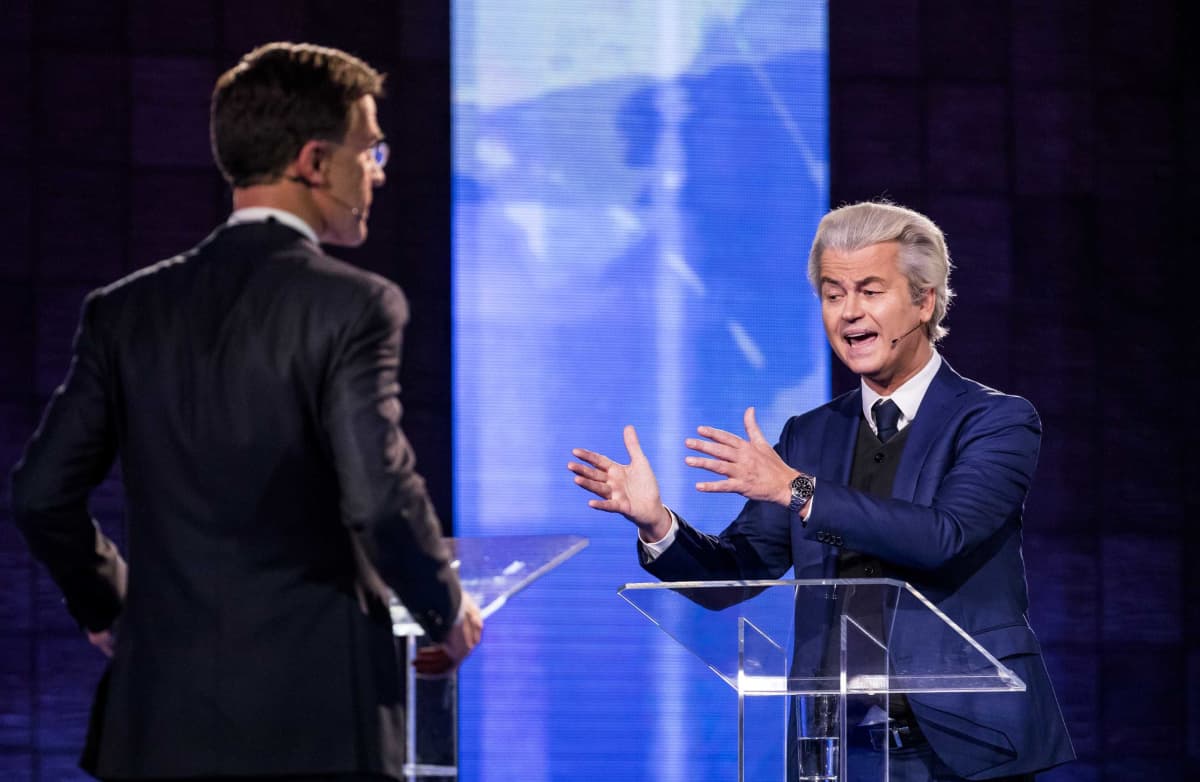 Hollannin pääministeri, oikeistoliberaalipuolue VVD:n johtaja Mark Rutte selin kameraan, kuvan vasemmalla puolella, ja Vapauspuolueen johtaja, harmaatukkainen Geert Wilders oikealla, kasvot kameraan päin, väittelevät tv-studiossa.