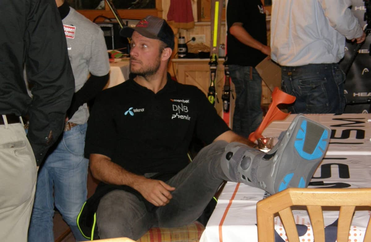 Norjalainen alppihiihtäjä Aksel Lund Svindal istuu jalka paketissa.