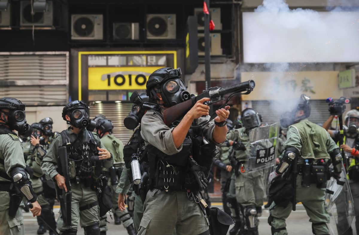 Polisen avfyrar tårgasgranater mot demonstranter i Hongkong på söndagen. 