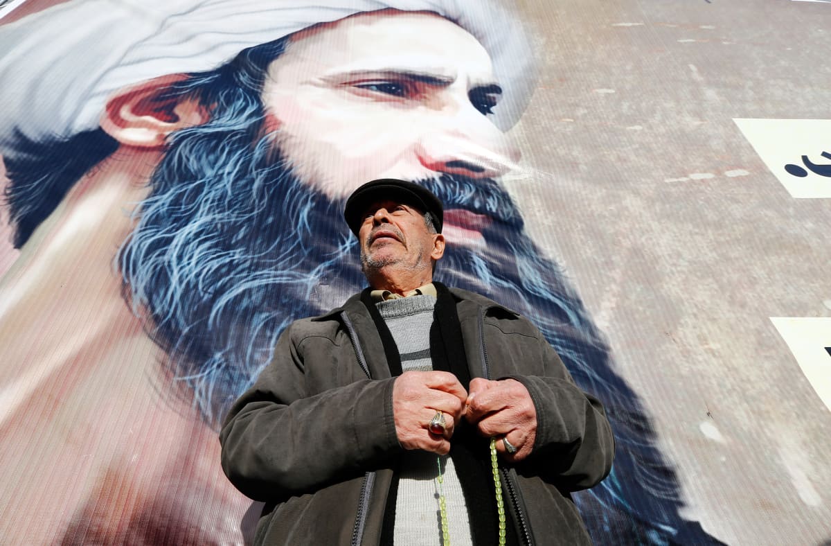 Iranilaismies seisoo shiialaisen uskonoppineen Nimr al-Nimrin julisteen edessä.