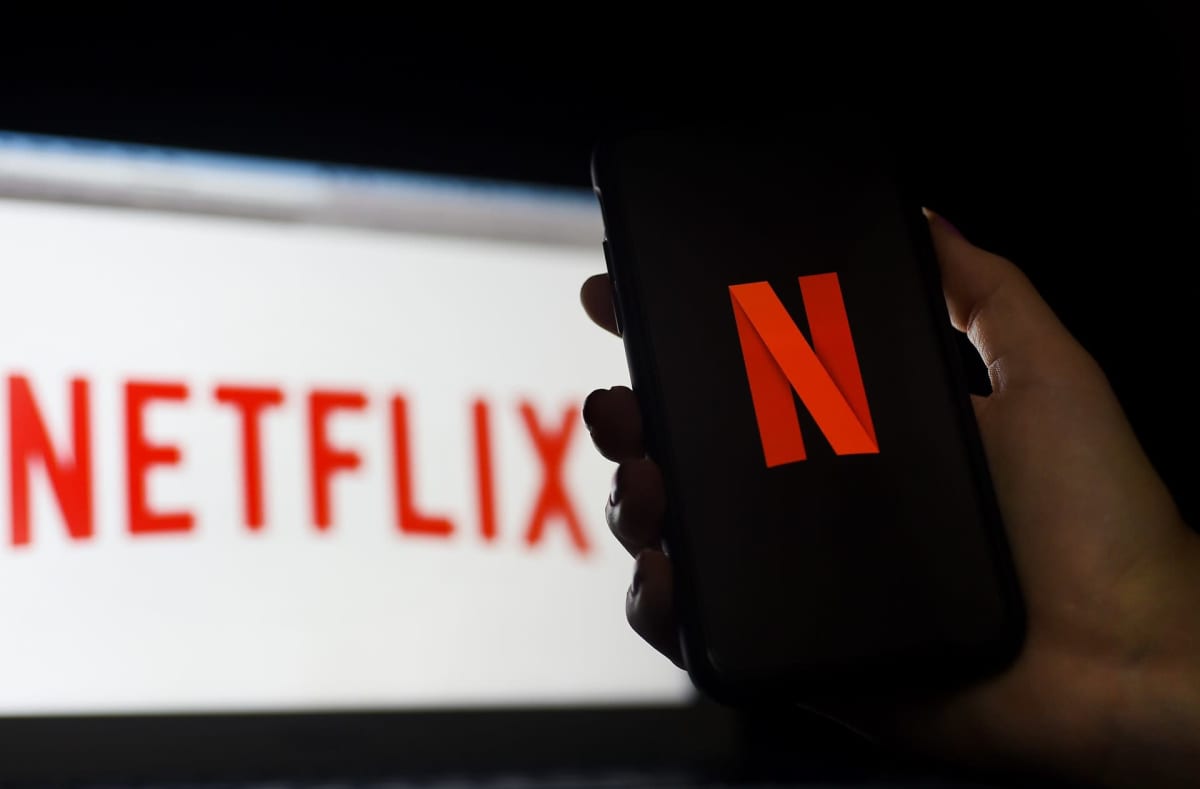 Suoratoistopalvelu Netflixin logo älypuhelimen ja tietokoneen näytöllä.