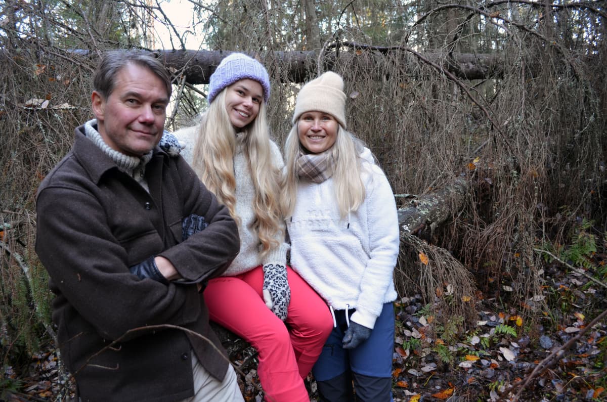 Pellikan perhe, isä, tytär ja äiti, suojelemallaan metsäpalstalla Jalasjärvellä kaatuneiden puiden luona.