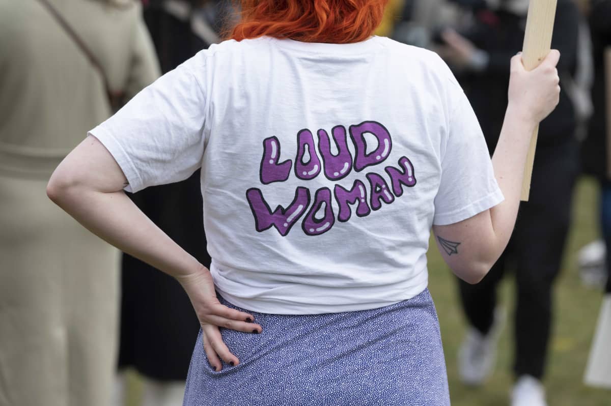 Nainen on pukeutunut paitaan, jossa lukee Loud woman.