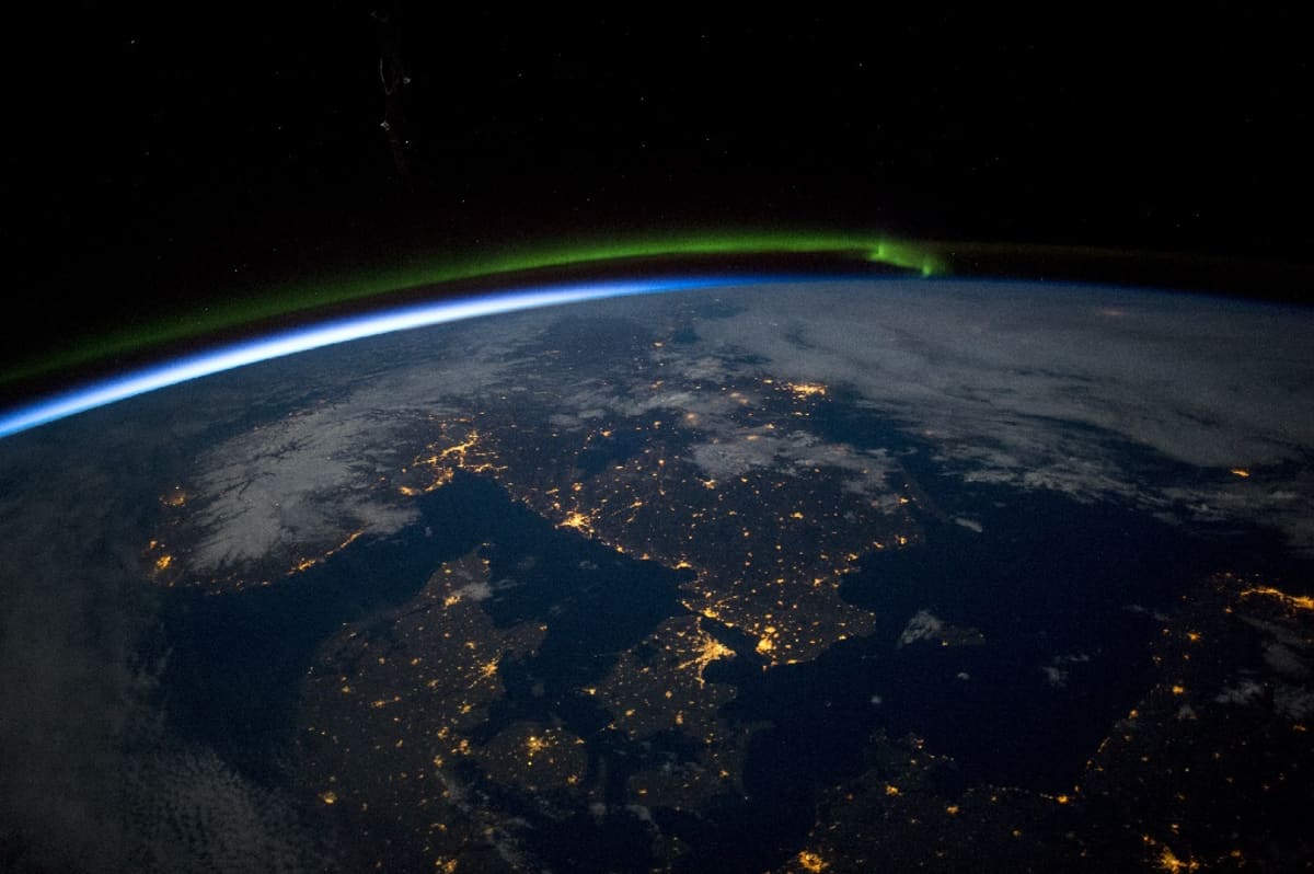 Maapallon kaareva pinta, jolla kaupungit näkyvät valokeskittyminä. 