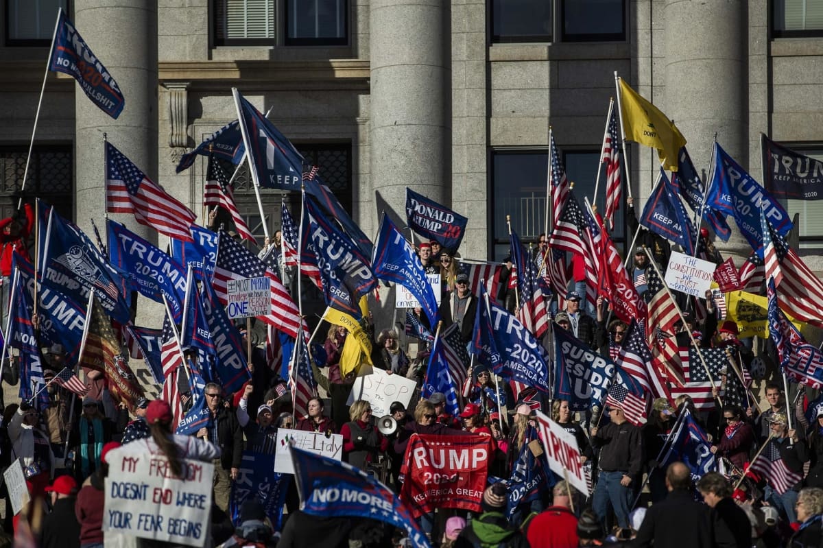 Trumpia tukevia lippuja kantava väkijoukko kongressirakennuksen portailla