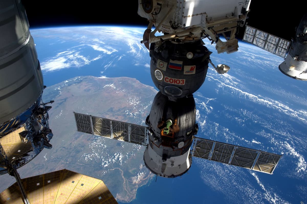 ISS:stä kohti Maata otetussa kuvassa keskellä Sojuz-alus. 