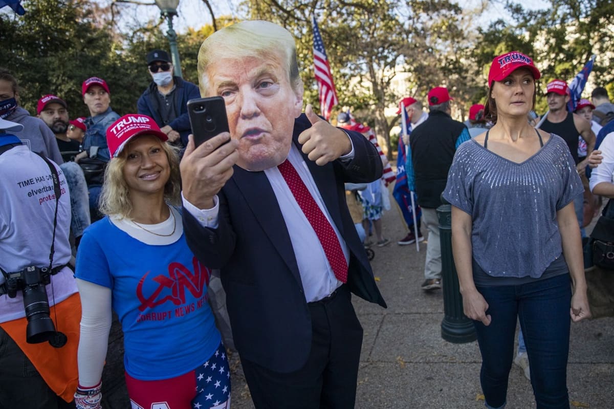 Trumpia puolustava mielenosoittaja otti itsestään selfien naamari päässä Washingtonissa lauantaina.