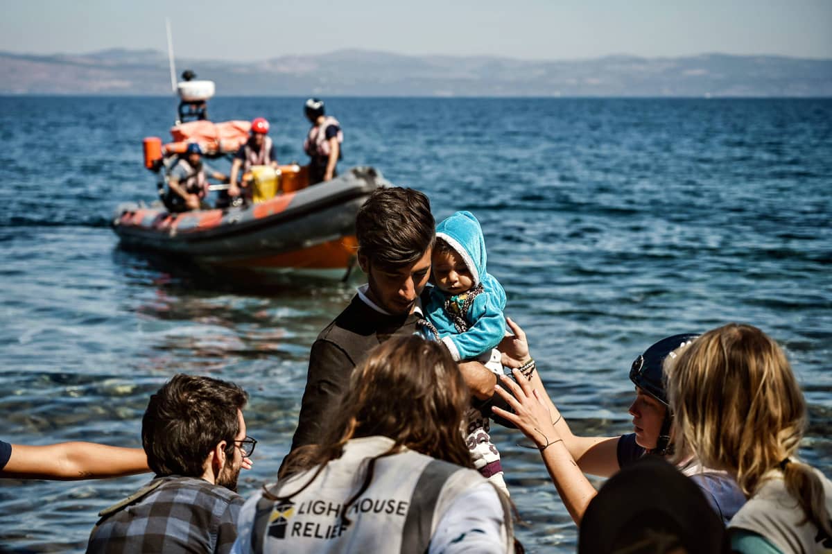 Pelastajat auttavat lesboksen saarelle saapuvia pakolaisia 16. syyskuuta.