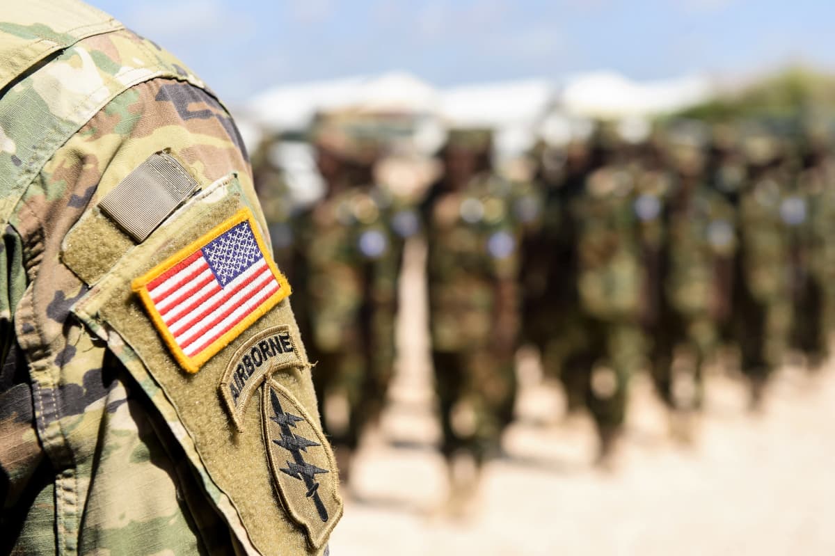 Etualalla näkyy soitlaan olkapää ja käsivarressa Yhdysvaltain lippu ja 101. maahanlaskujoukkojen tunnus. Taustalla näkyy somalialaisia sotilaita.