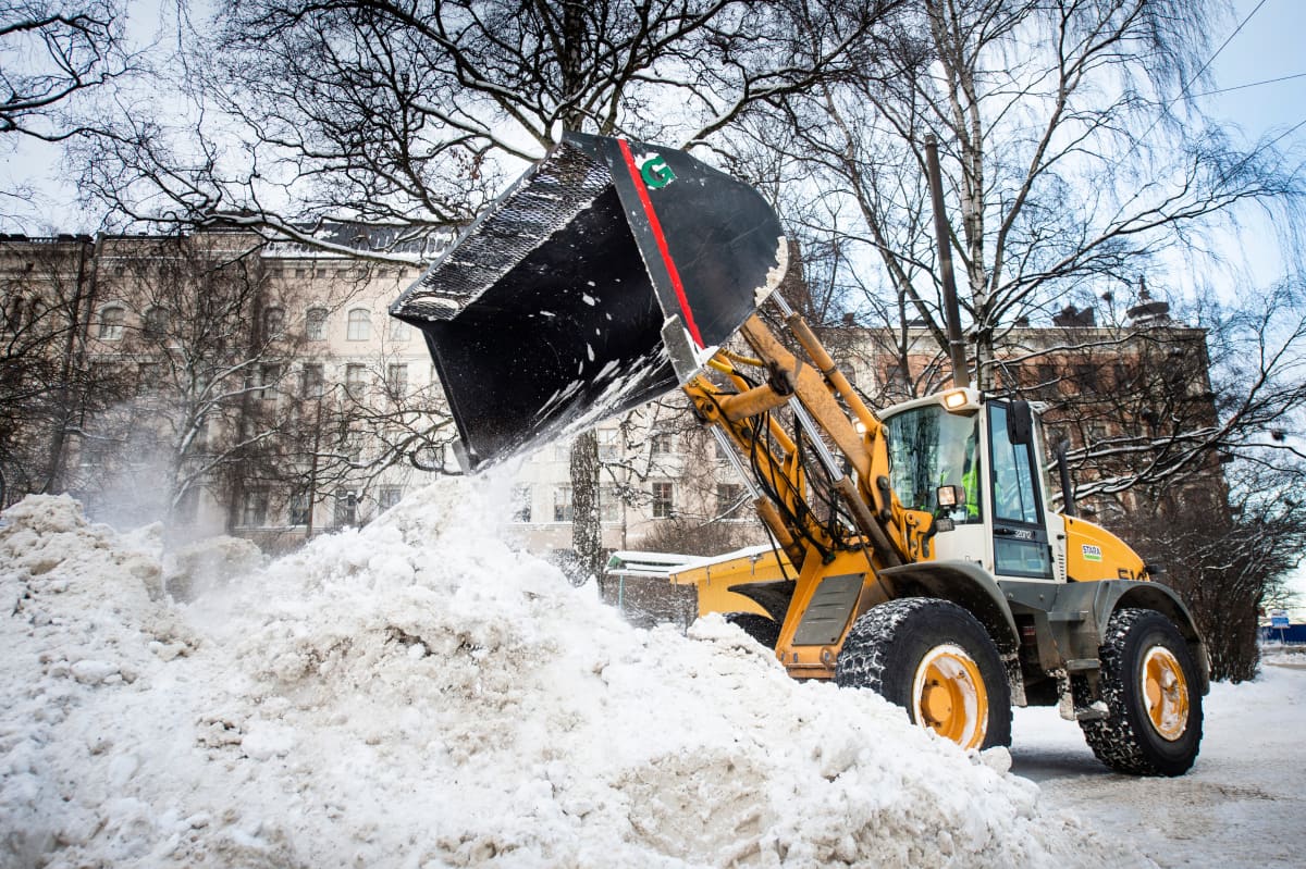 Traktori kasaa lunta