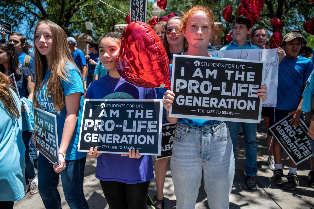 Kolme nuorta tyttöä mielenosoituksessa aborttia vastaan.