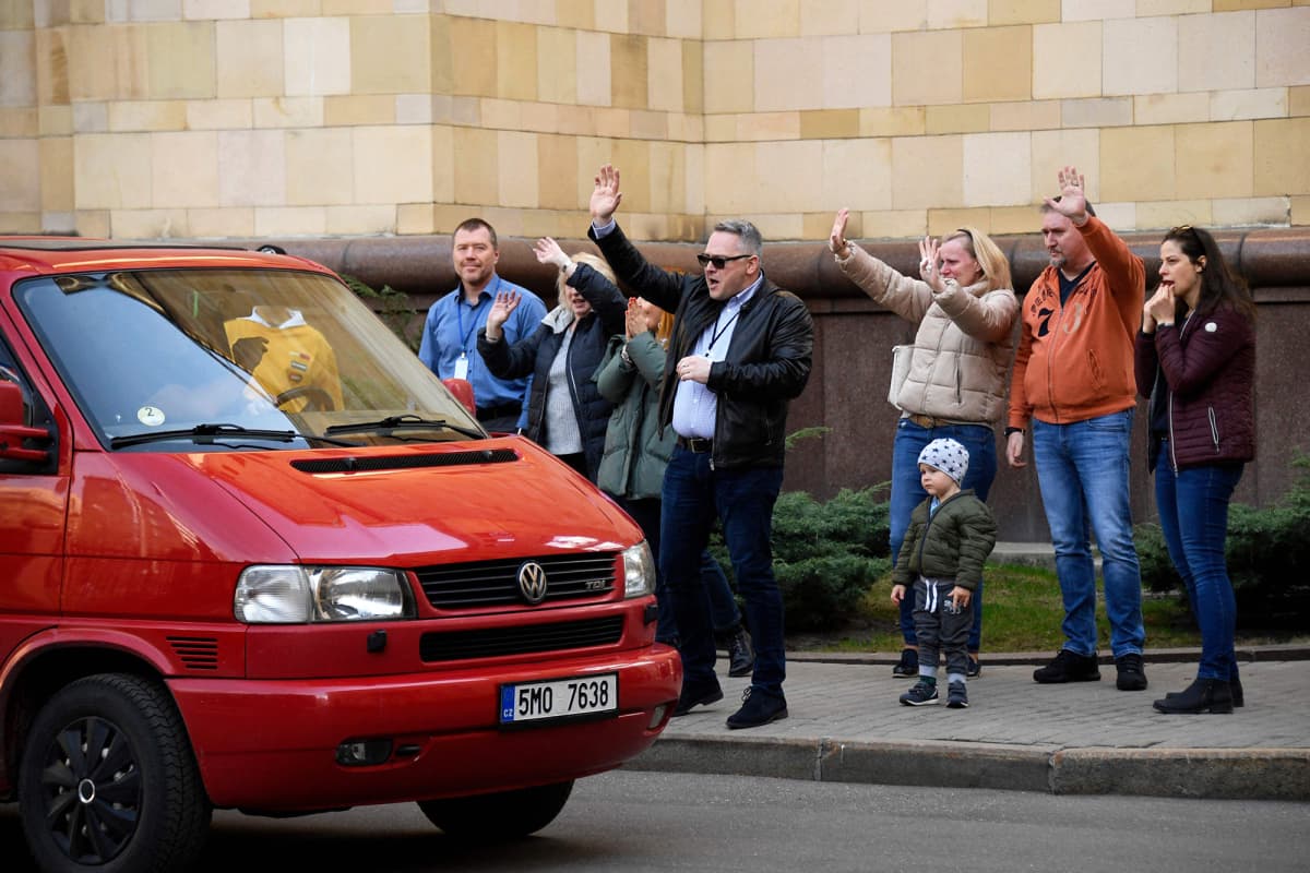 Tšekkiläiset diplomaatit vilkuttavat Moskovan suurlähetystön alueelta autolla poistuville.