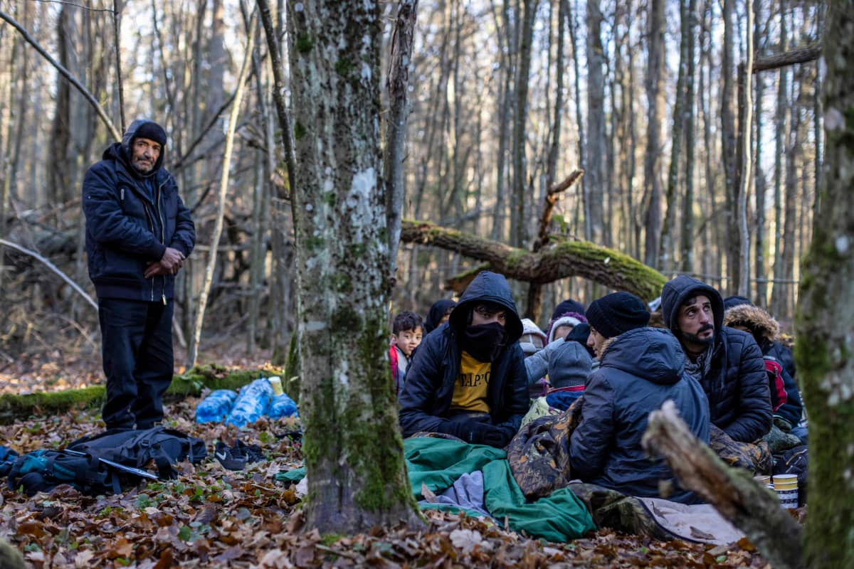 Siirtolaisia metsässä Puolassa.