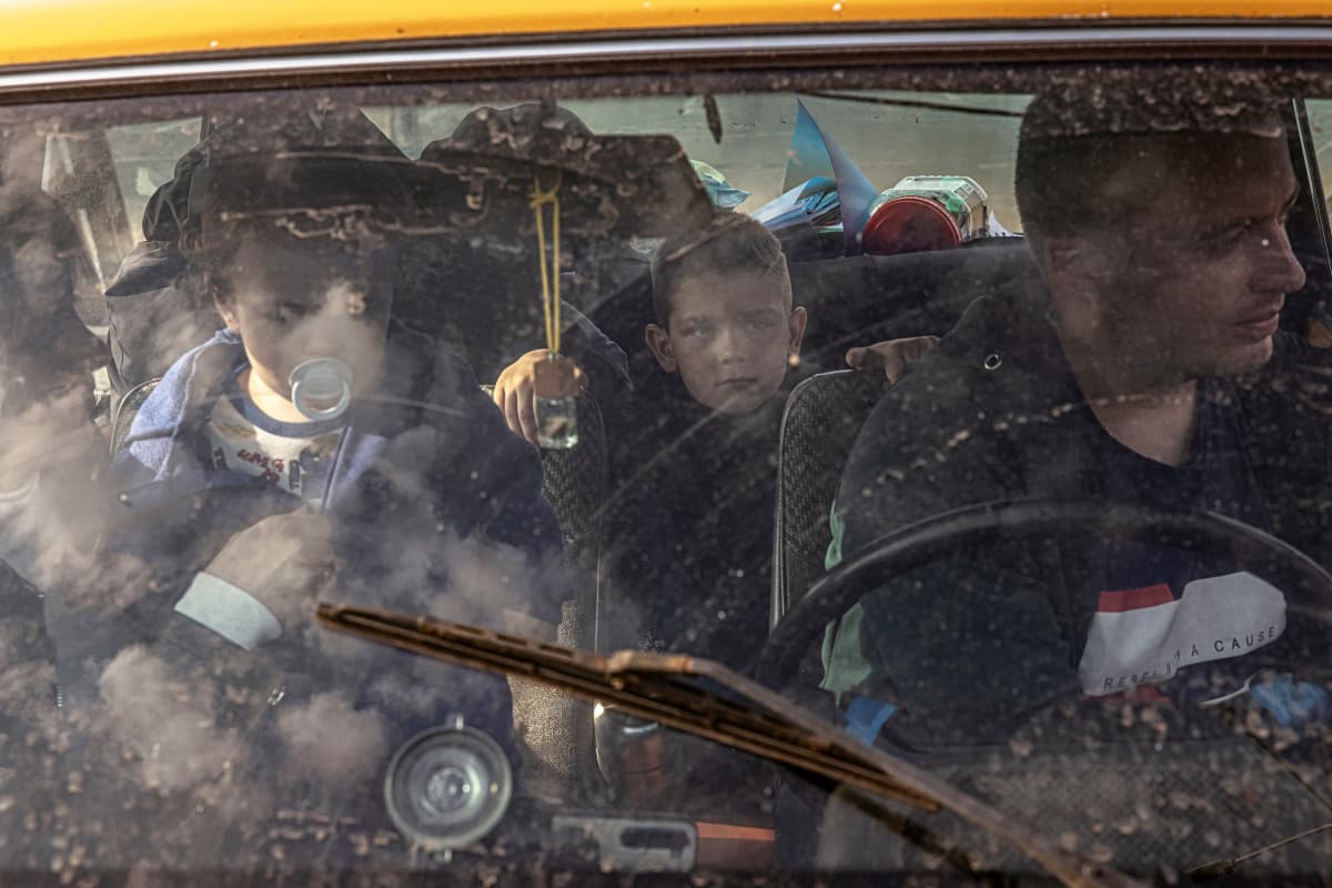 Aikuisia ja lapsia henkilöautossa.