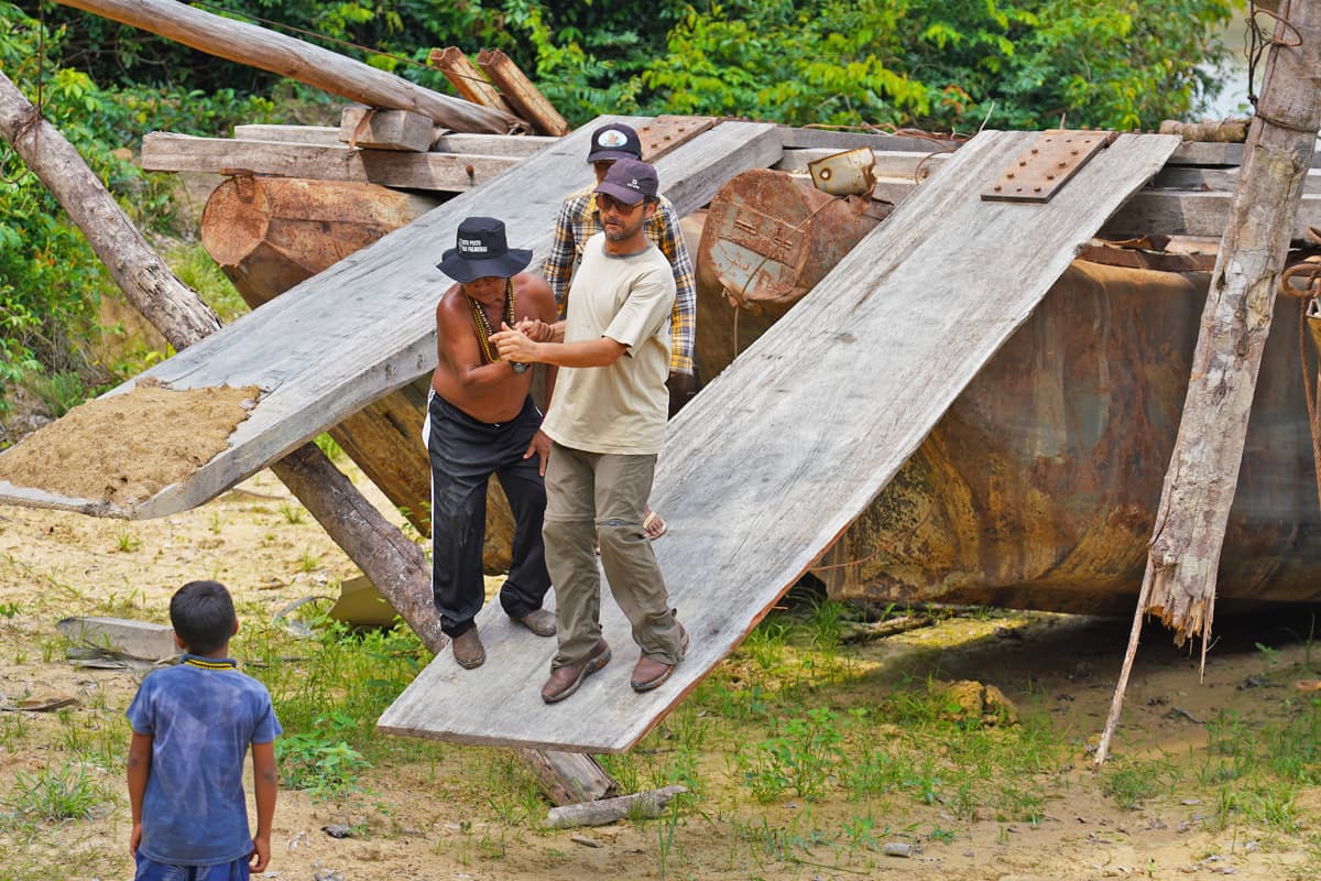 Mundurukujen tiedusteluretkikunnan jäseniä puunhakkaajien lautan ajorampilla.
