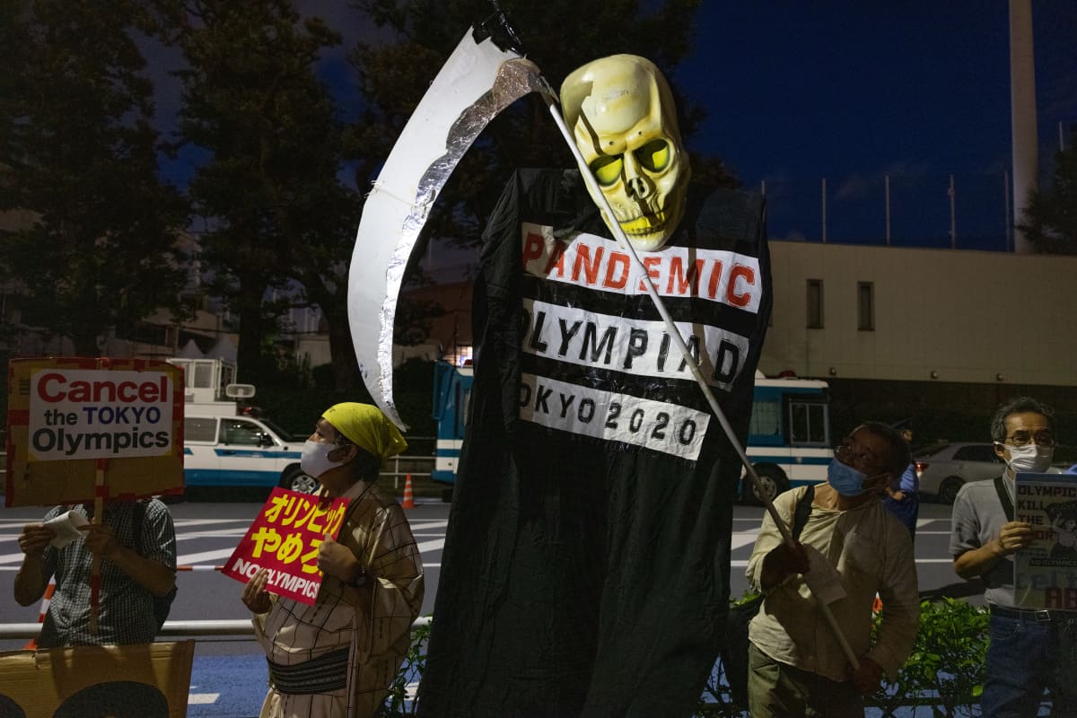 Mielenosoittaja Tokion olympiastadionin ulkopuolella.