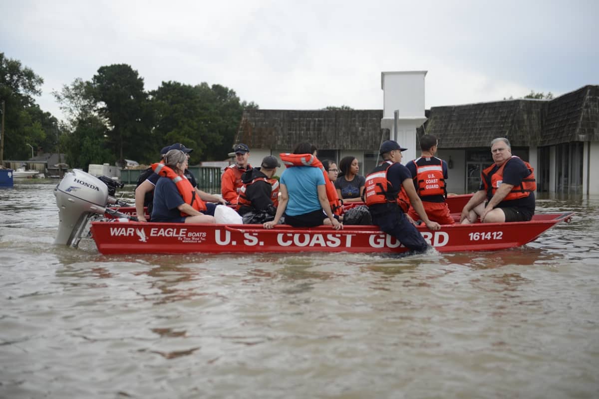 Evakuoitavia ihmisiä istuu veneessä. 