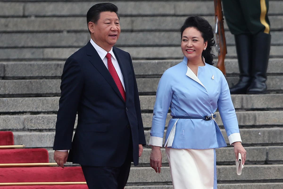 Xi ja Peng kävelevät punaista mattoa pitkin alas portaita.