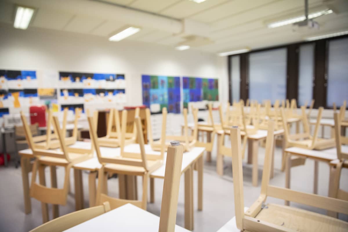 Luokkahuone jossa tuolit nostettu pöydille