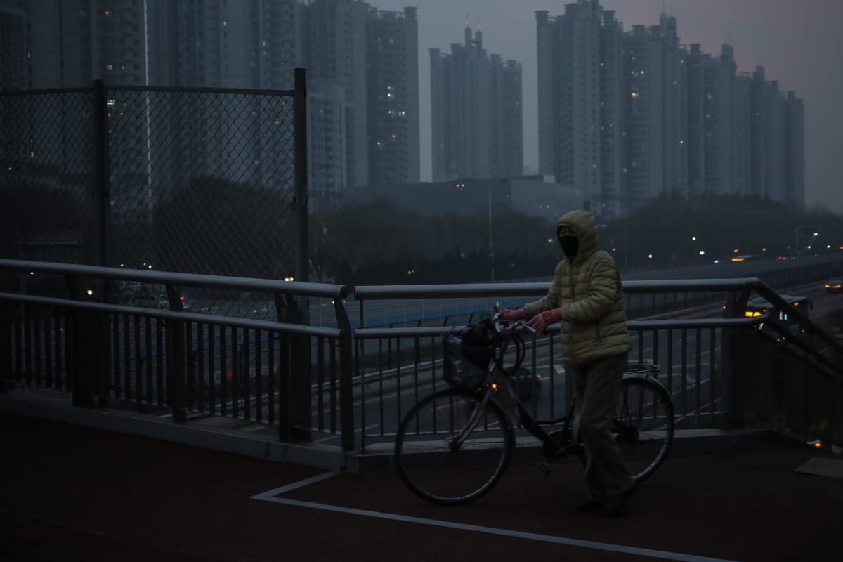 Henkilö suojautuneena kasvomaskiin ilmanlaadun ollessa huono Pekingissä.
