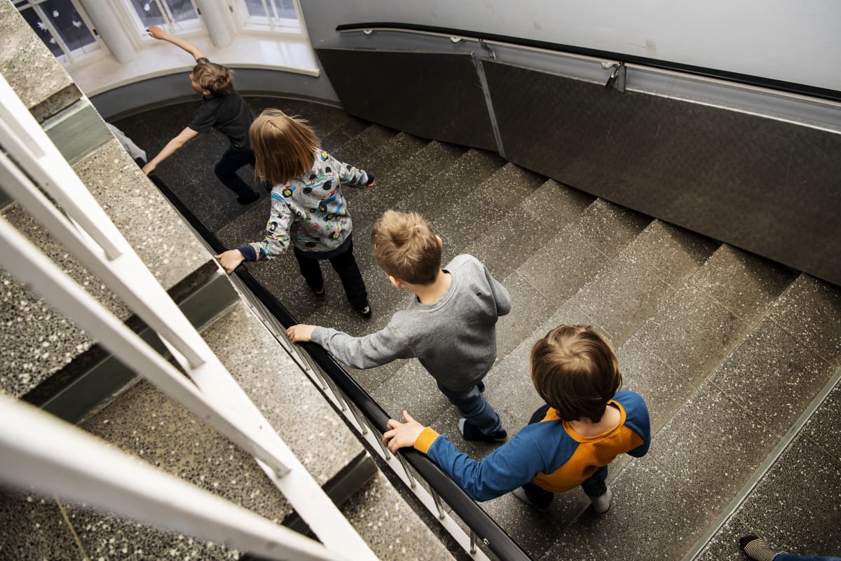 Kuvassa oppilaat kulkevat jonossa portaita kohti ruokalaa.