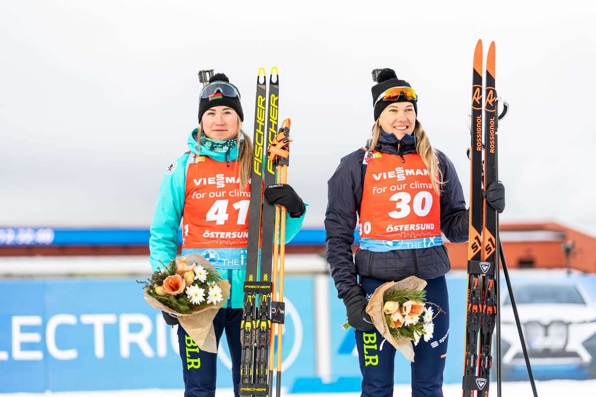 Valko-Venäjän Dzinara Alimbekava ja Hanna Sola kukitettavana Östersundin maailmancupin pikakilpailun jälkeen.