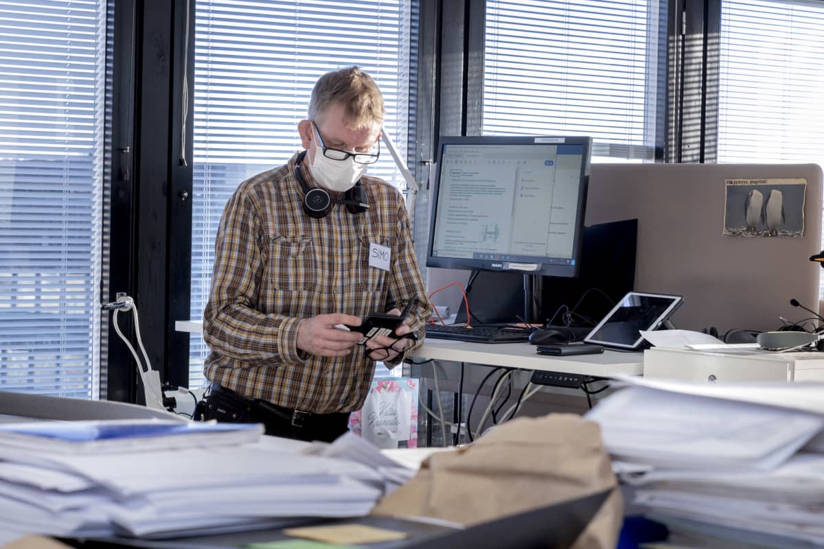 Koronajäljittäjä Simo Sajama tutkii puhelinta työpaikallaan.