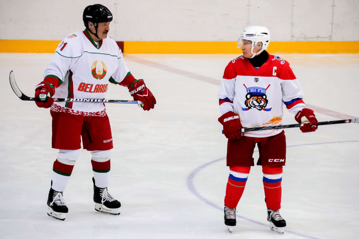 Lukašenka ja Putin ovat jääkiekkokaukalossa jääkiekkoilijan varusteissa.