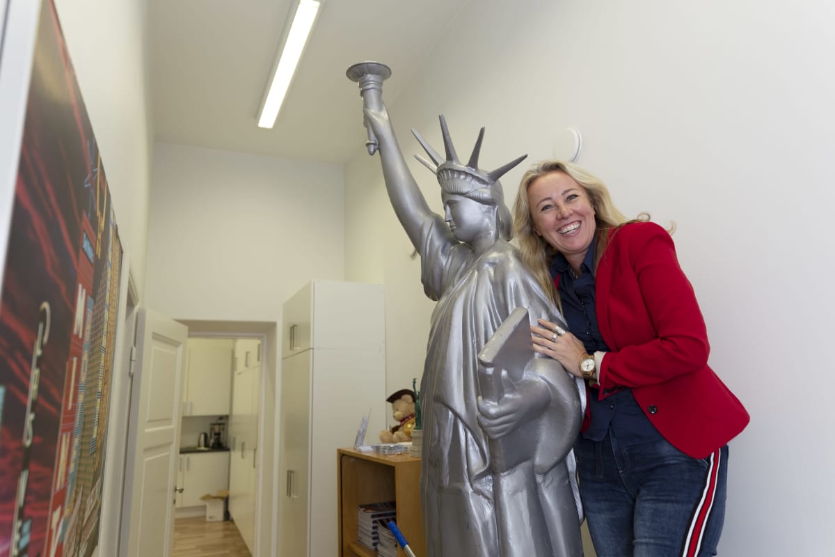 Joe Bidenia äänestävä Lena Grenat halaa nauraen toimiston käytävällä olevaa vapaudenpatsaan pienoismallia.