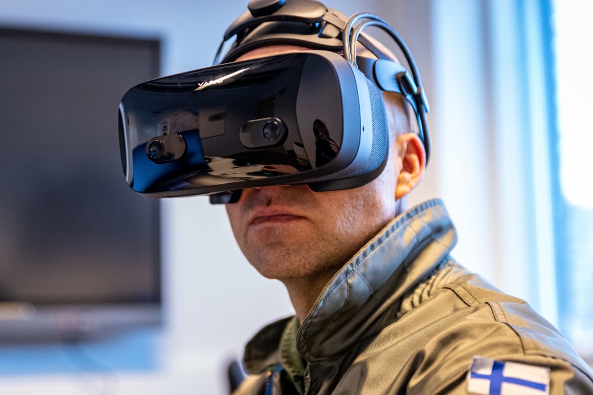Lähikuva miehestä jolla on lentäjän haalari ja VR-lasit päässä.