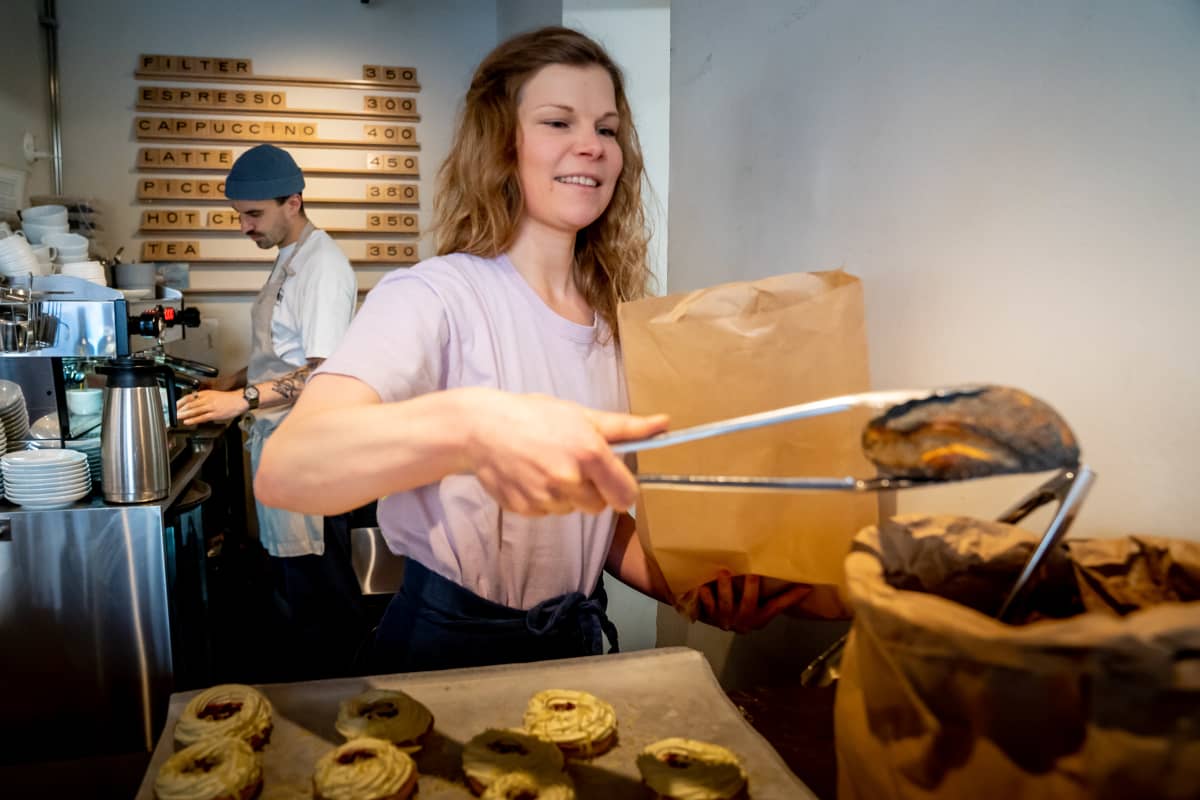 Kahvilatyöntekijä Riikka Lamminen  laittaa sämpylöitä pussiin kahvila Way Bakeryssä
