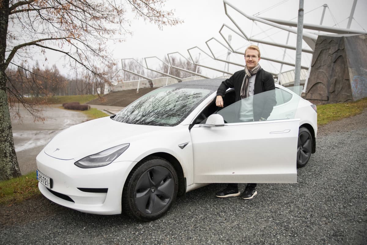 Simo Kettunen nojaa valkoiseen Teslaansa.