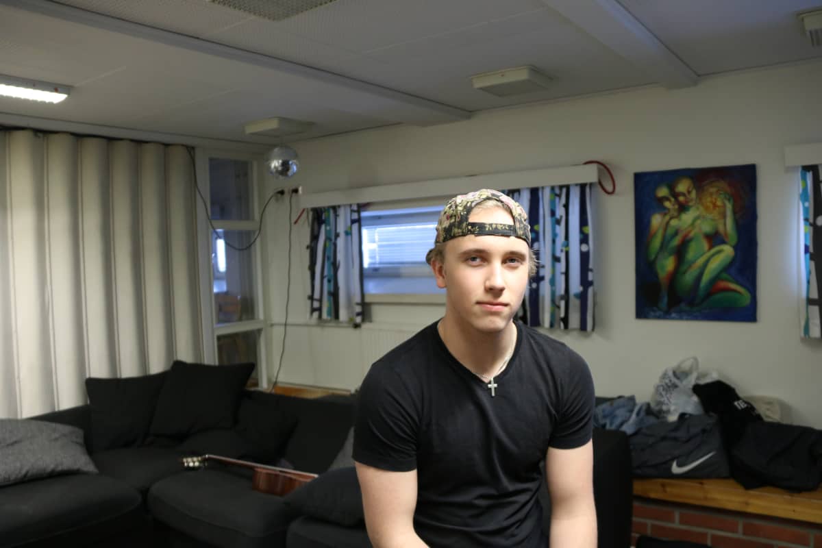 Tuomas Hartikainen istuu Joensuun lyseon lukion kahvion sohvalla
