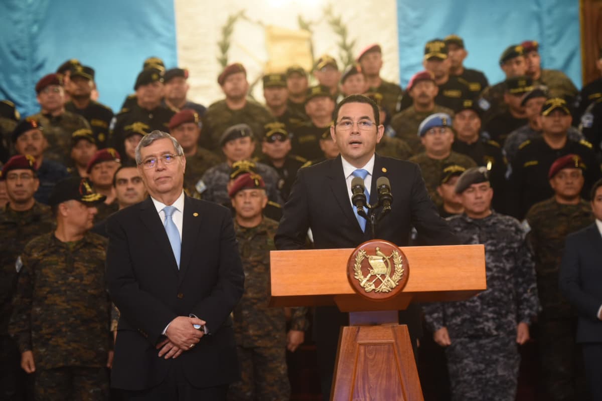 Kuvassa presidentti puhuu puhujanpöntössä, taustalla armeijan barettipäisiä sotilaita.