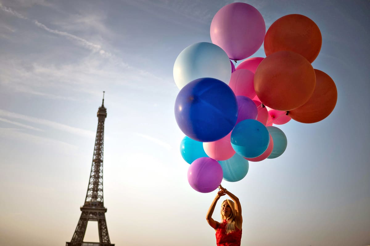 Nainen poseraa ilmapallojen kanssa Pariisin helteissä 25. heinäkuuta 2019.