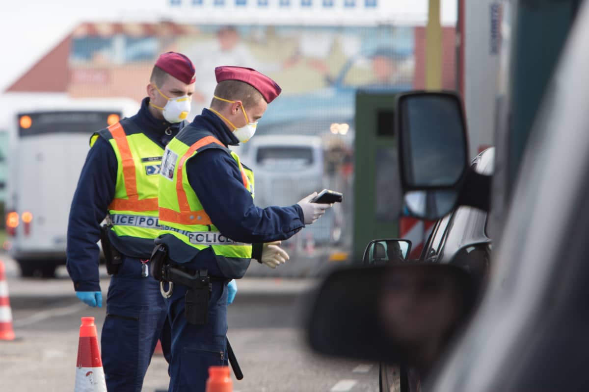 Unkarilaisia poliiseja mittaamassa autolijoiden lämpötiloja Nickelsdorfin raja-asemalla, Unkarin ja Itävallan rajalla.