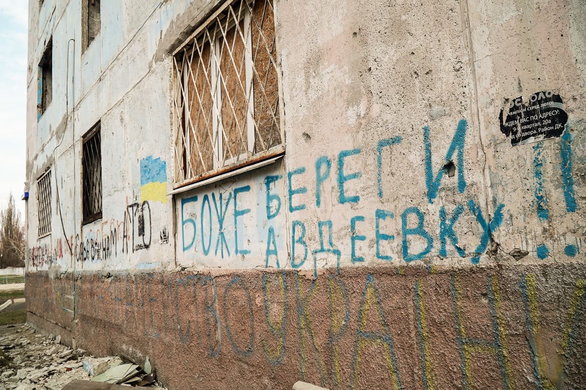 “Jumala, pelasta Avdijivka”, lukee kerrostalon seinässä. Viereen on maalattu Ukrainan lippu.